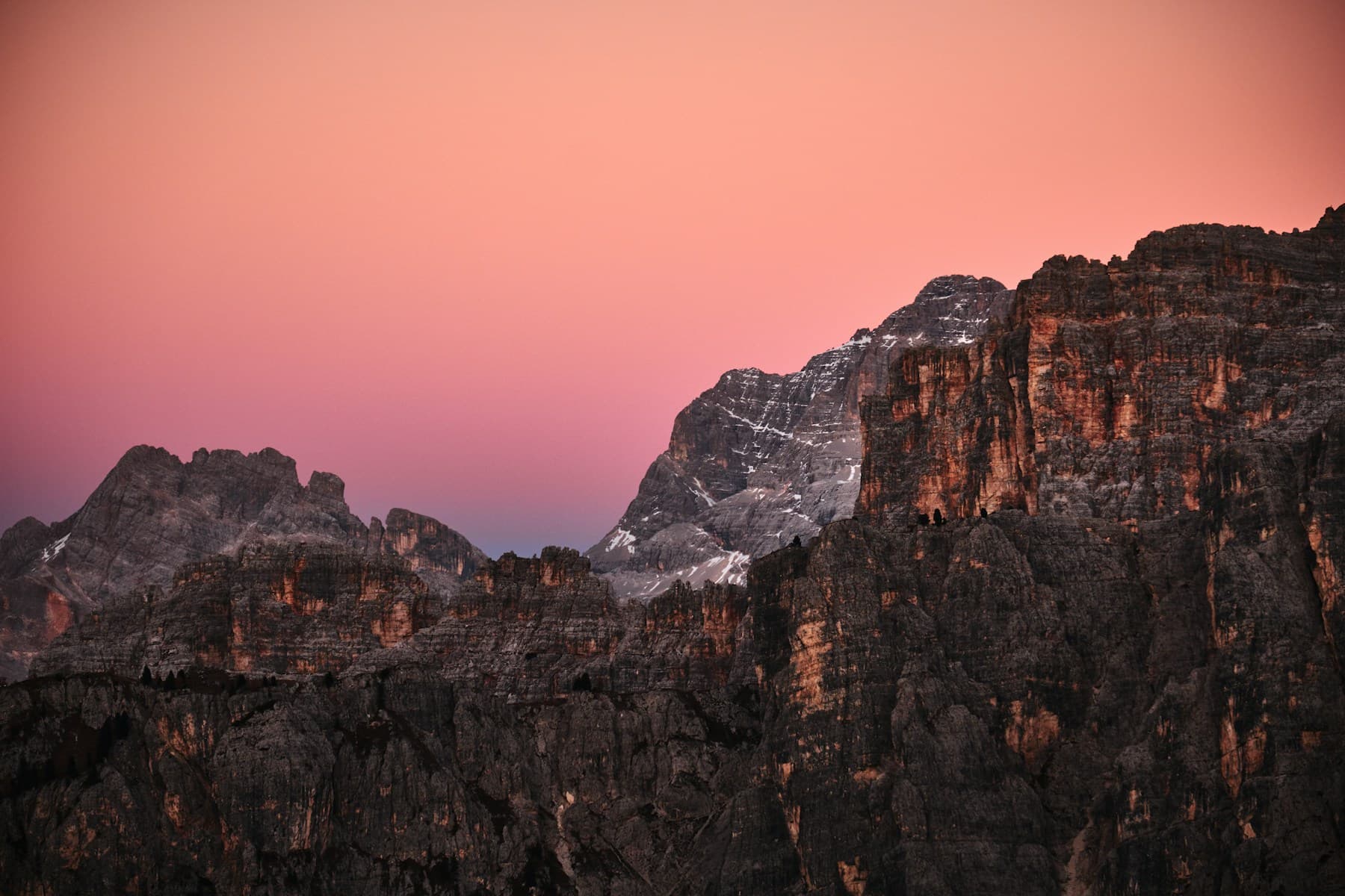 Golden sunlight on rugged mountains above alpine woodland